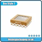 Elegant gold and white gift box with a clear window top and polka dot base