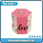 Hexagon-shaped wedding cake favor box with pink and white heart-themed design