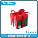 Festive Christmas gift box in red and green with snowman print and red ribbon bow.