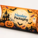 Orange Halloween pillow gift box with pumpkins, bats and haunted house artwork.