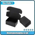 Black cardboard mailer-style box with open flaps, shown alongside a closed version for product packaging.