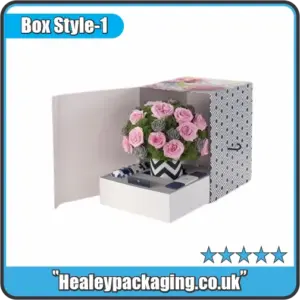Decorated floral presentation box with sliding drawer and a bouquet of pink and grey roses displayed inside.