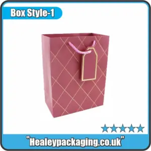 Elegant maroon gift bag with gold diamond pattern, pink rope handles, and matching gold-edged tag.
