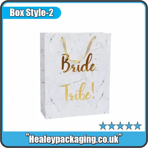 White marble gift bag with gold “Bride Tribe!” text and gold ribbon handles.