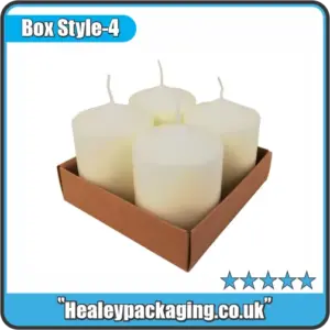 Three white pillar candles displayed with branded retail packaging sleeves.